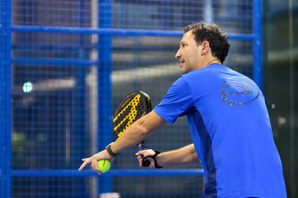 Carlos Ferretti coaching padel on an indoor court